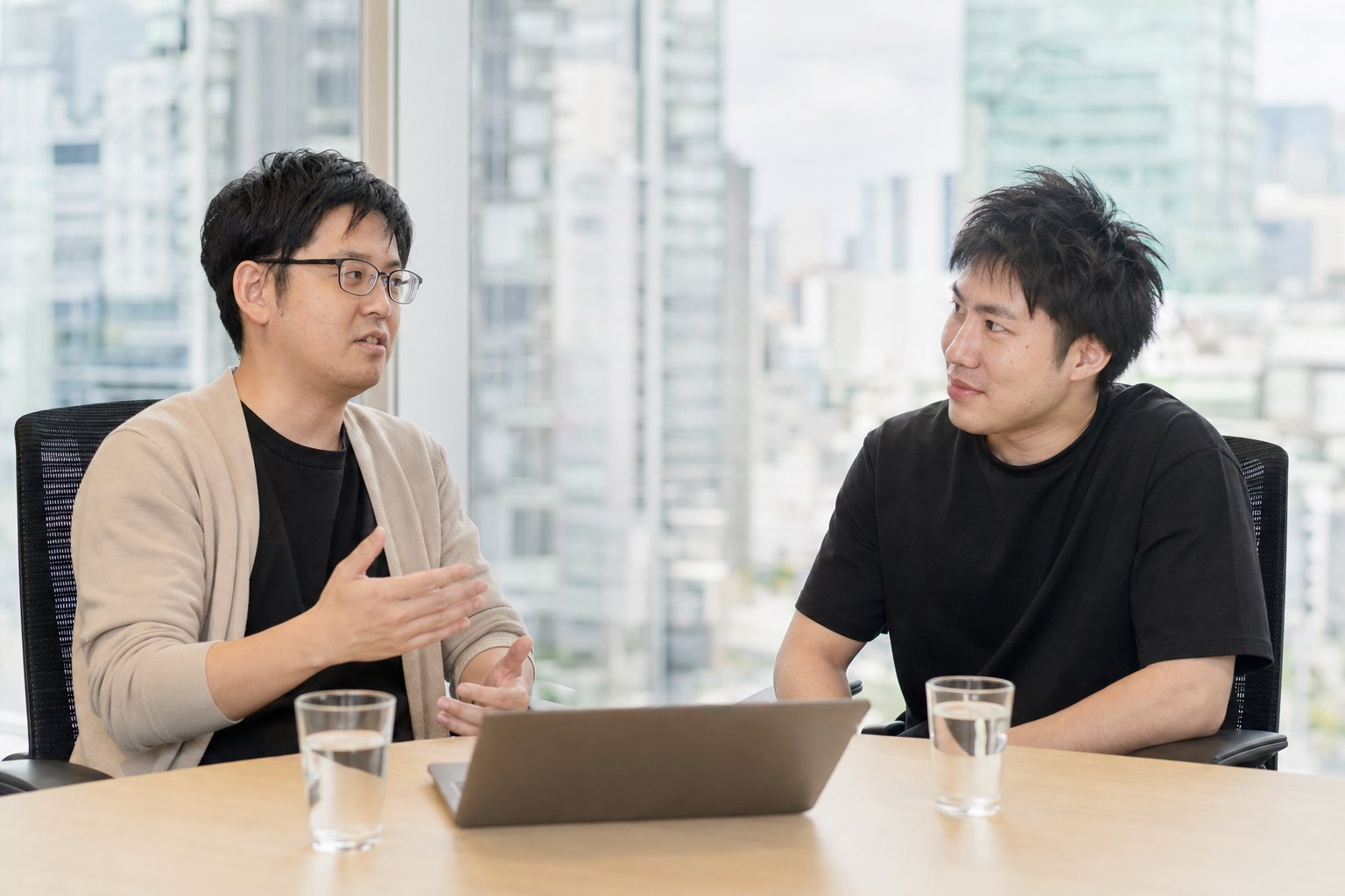 側原さんと澤さんが会議室で向かい合って話している